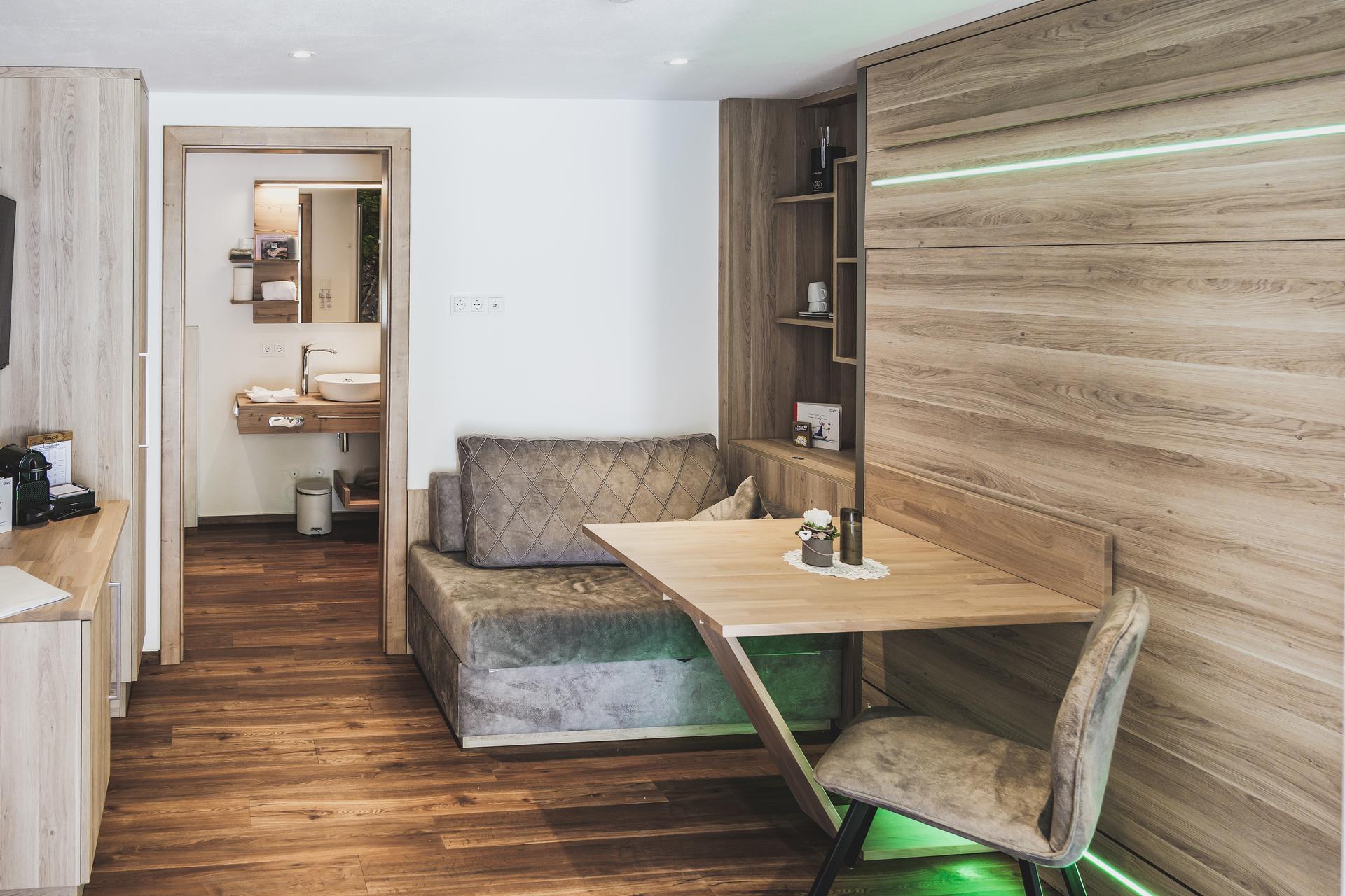 Wohn- und Essbereich mit ausklappbarem Tisch im Doppelzimmer Freiraum im Ur-Genuss in Heiterwang
