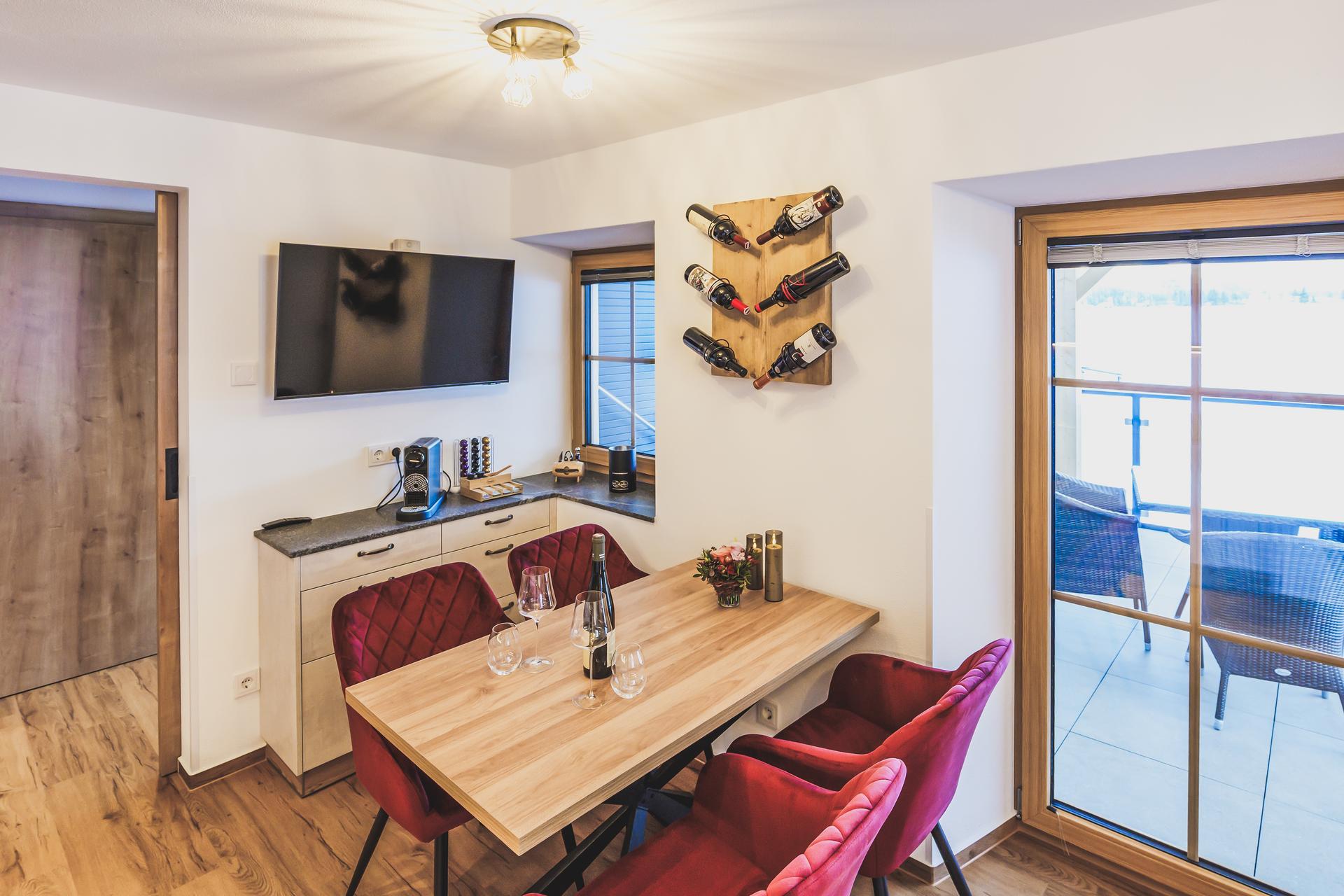 Gemütliche Genussecke mit Weinregal und gedecktem Tisch in der Ferienwohnung Schlafkammer im Ur-Genuss in Heiterwang