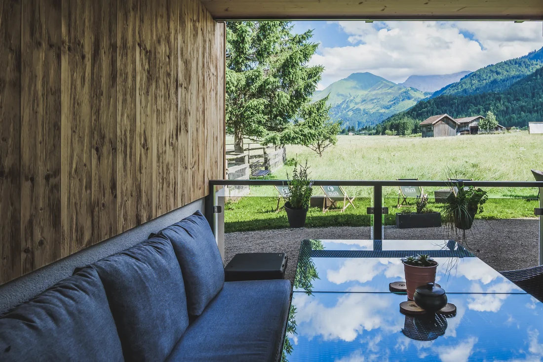 gemütliche Sitzecke mit Ausblick auf Blumenwiese vom Hotel Kuhstall in Heiterwang beim Ur-Genuss
